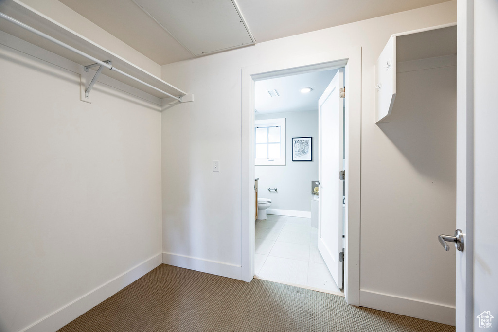 Spacious closet featuring attic access, carpet, and tile patterned floors