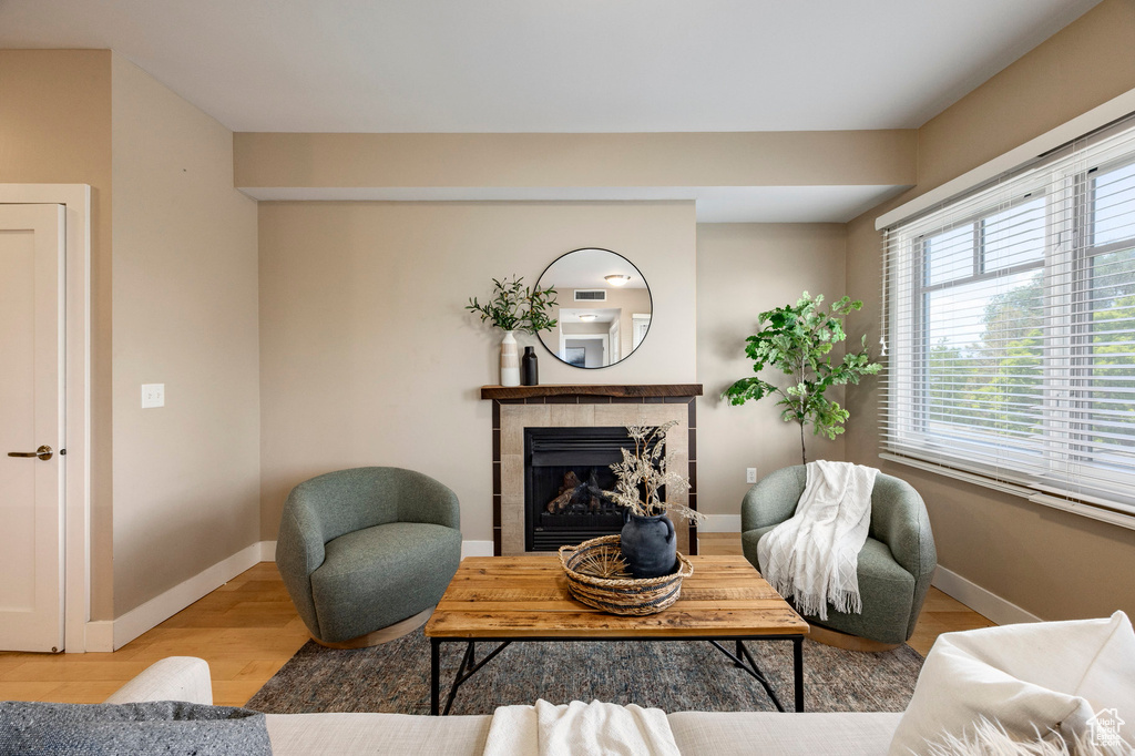Living area with a tiled fireplace and wood finished floors