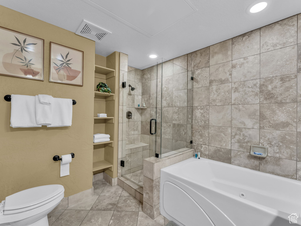 Full bath featuring a shower stall, a bath, built in shelves, and tile patterned floors