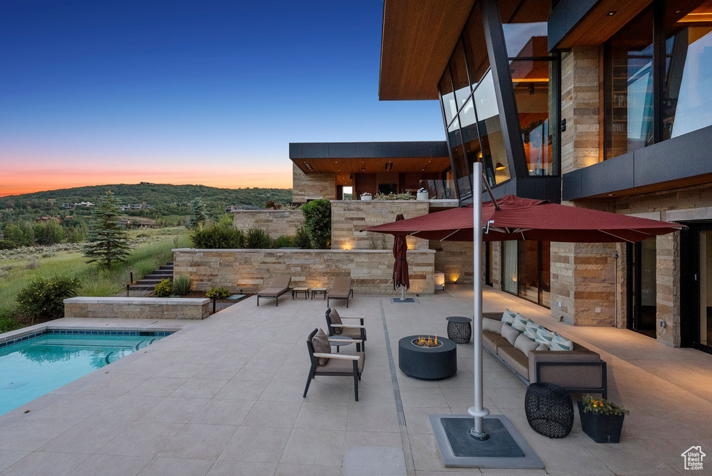Swimming pool with an outdoor fire pit and a patio area