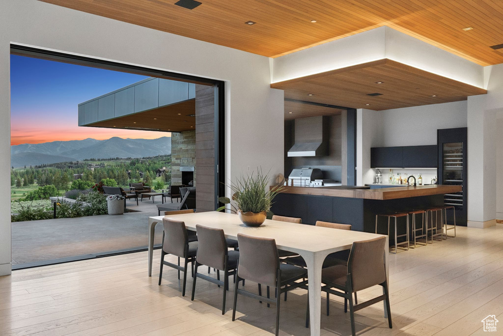 Dining area featuring wood ceiling, a mountain view, and light wood-style floors