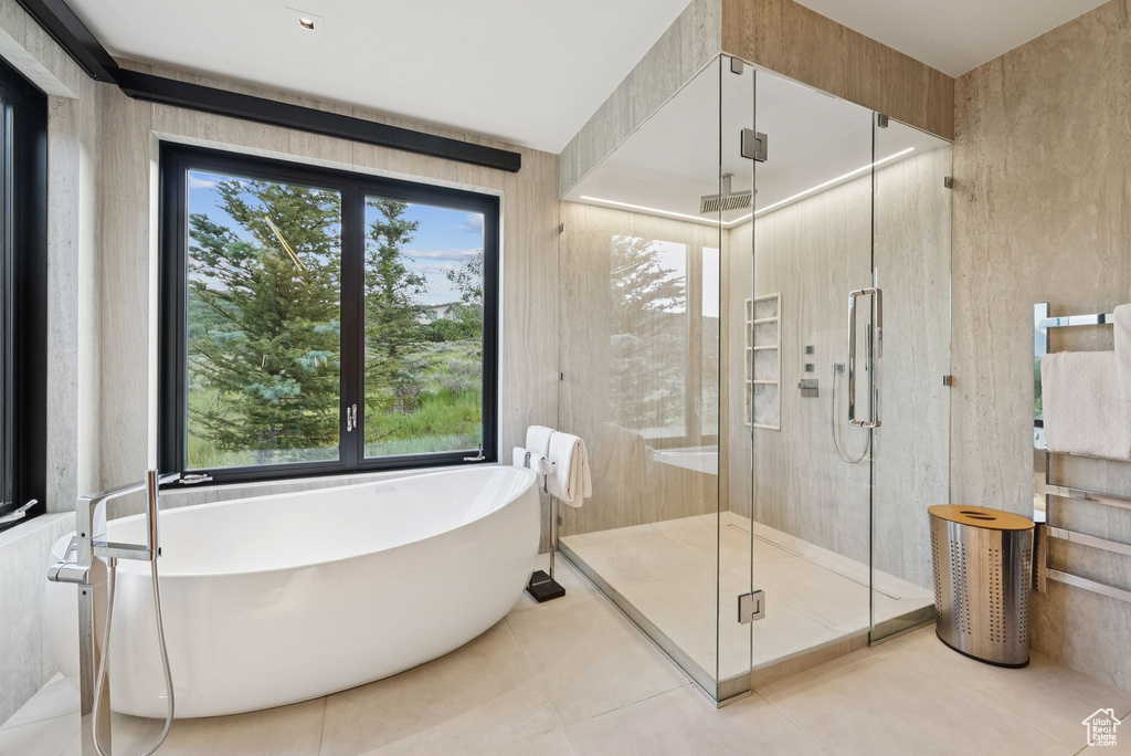 Full bath featuring a soaking tub, a shower stall, and tile patterned flooring