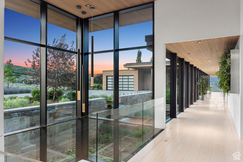 Staircase featuring floor to ceiling windows, wood finished floors, wood ceiling, and a high ceiling