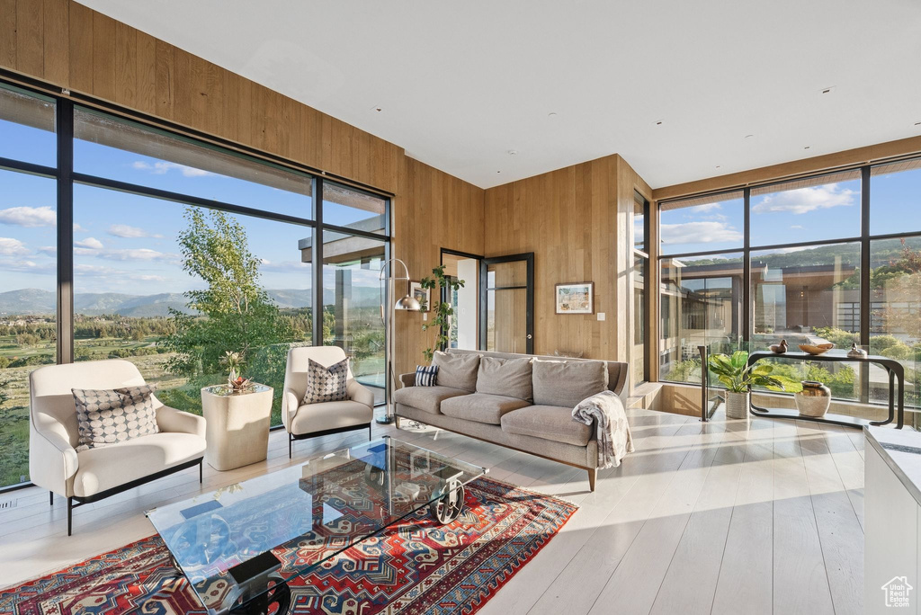 Living room with wooden walls, a mountain view, and wood finished floors