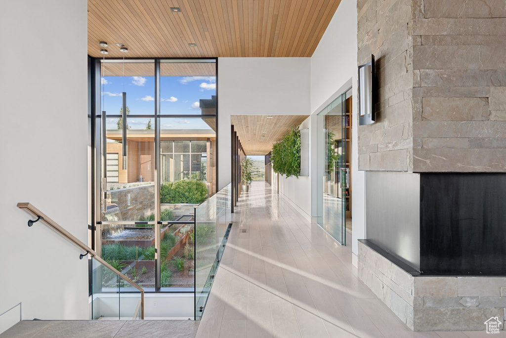Stairway featuring expansive windows, wood ceiling, and a fireplace