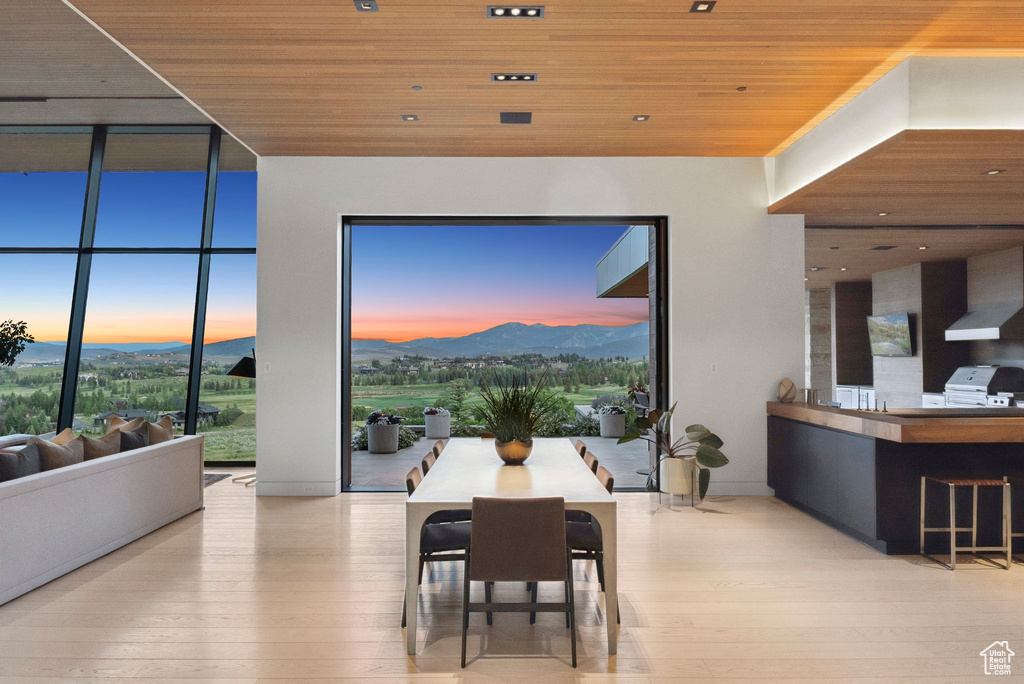 Dining space featuring wood ceiling, a mountain view, wood-type flooring, and floor to ceiling windows