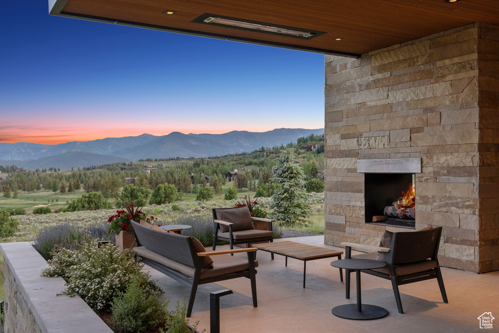 View of patio / terrace featuring an outdoor stone fireplace and a mountain view