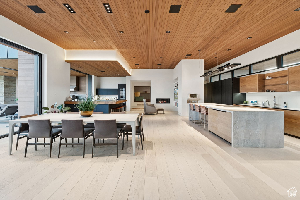 Dining space with wooden ceiling and light wood-style flooring