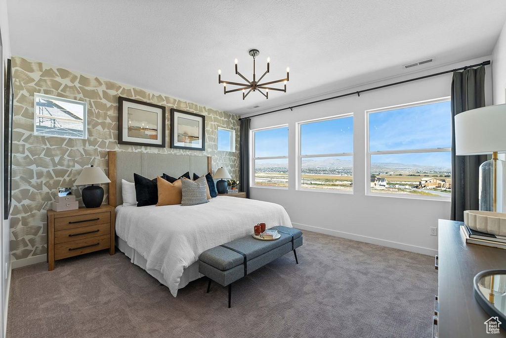 Carpeted bedroom with baseboards and a chandelier