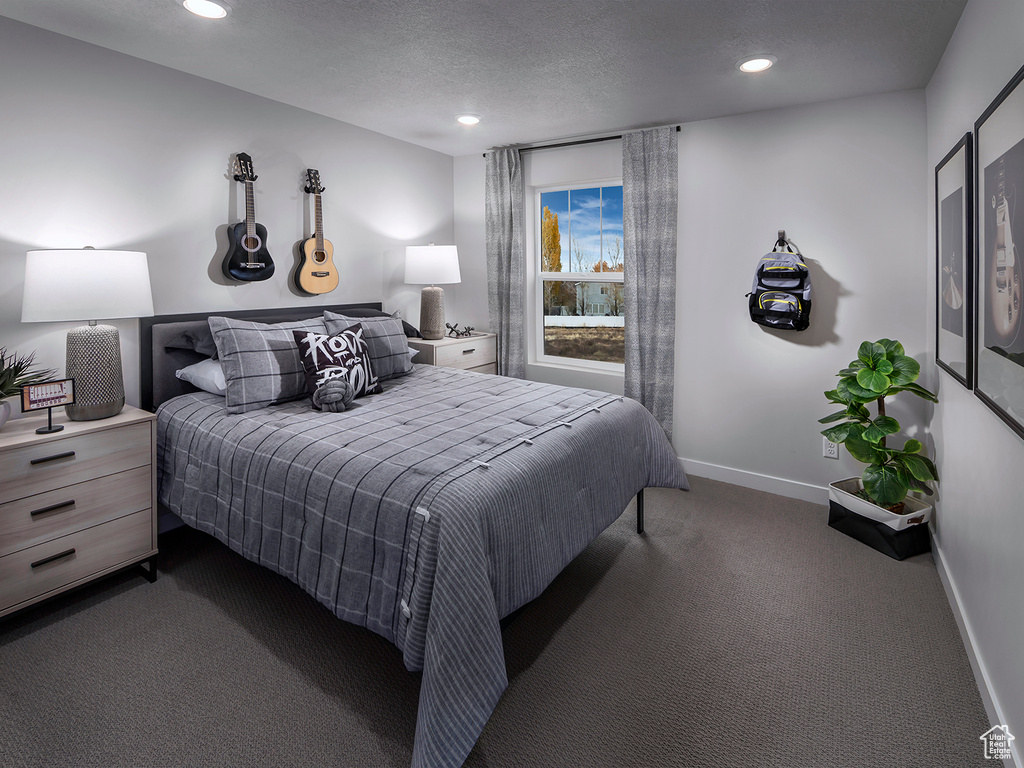 Bedroom featuring dark colored carpet, recessed lighting, and a textured ceiling