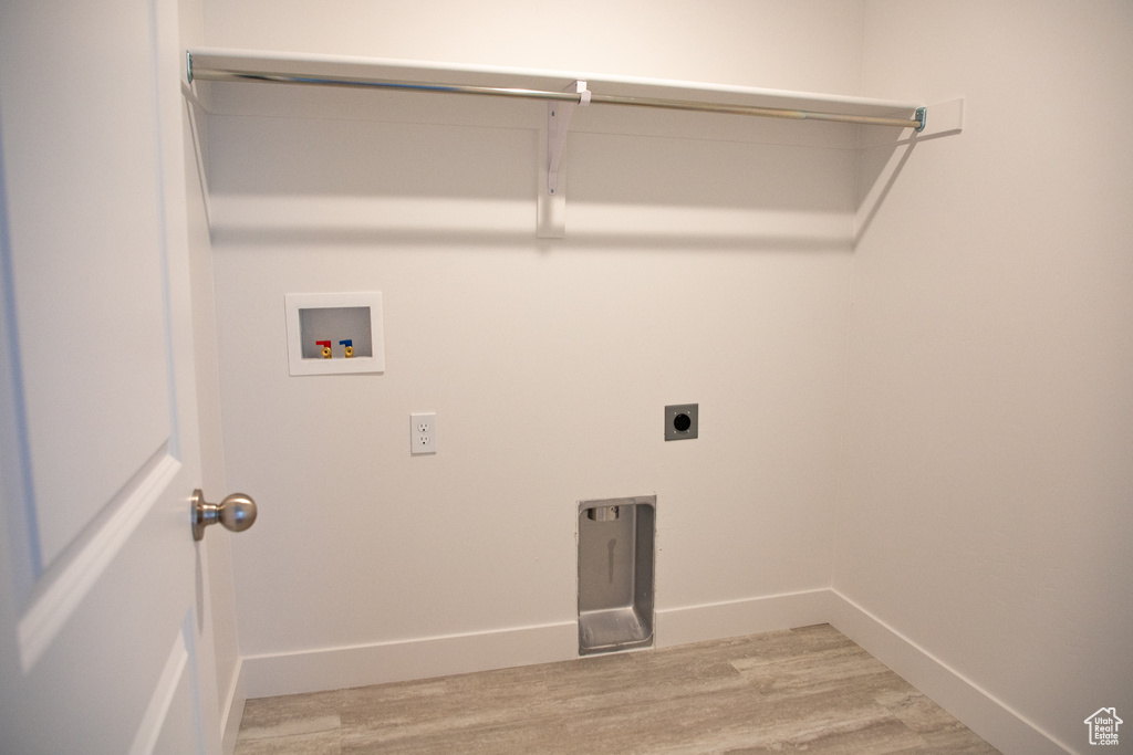 Washroom with hookup for a washing machine, light wood-type flooring, and electric dryer hookup