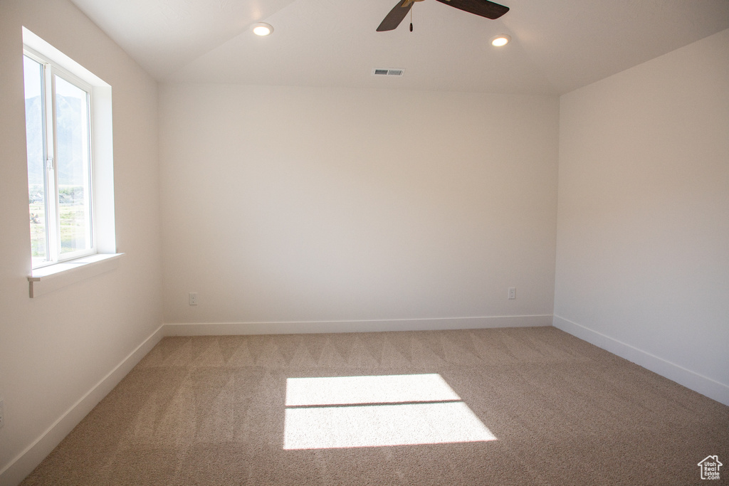Empty room featuring light colored carpet, healthy amount of natural light, a ceiling fan, and recessed lighting