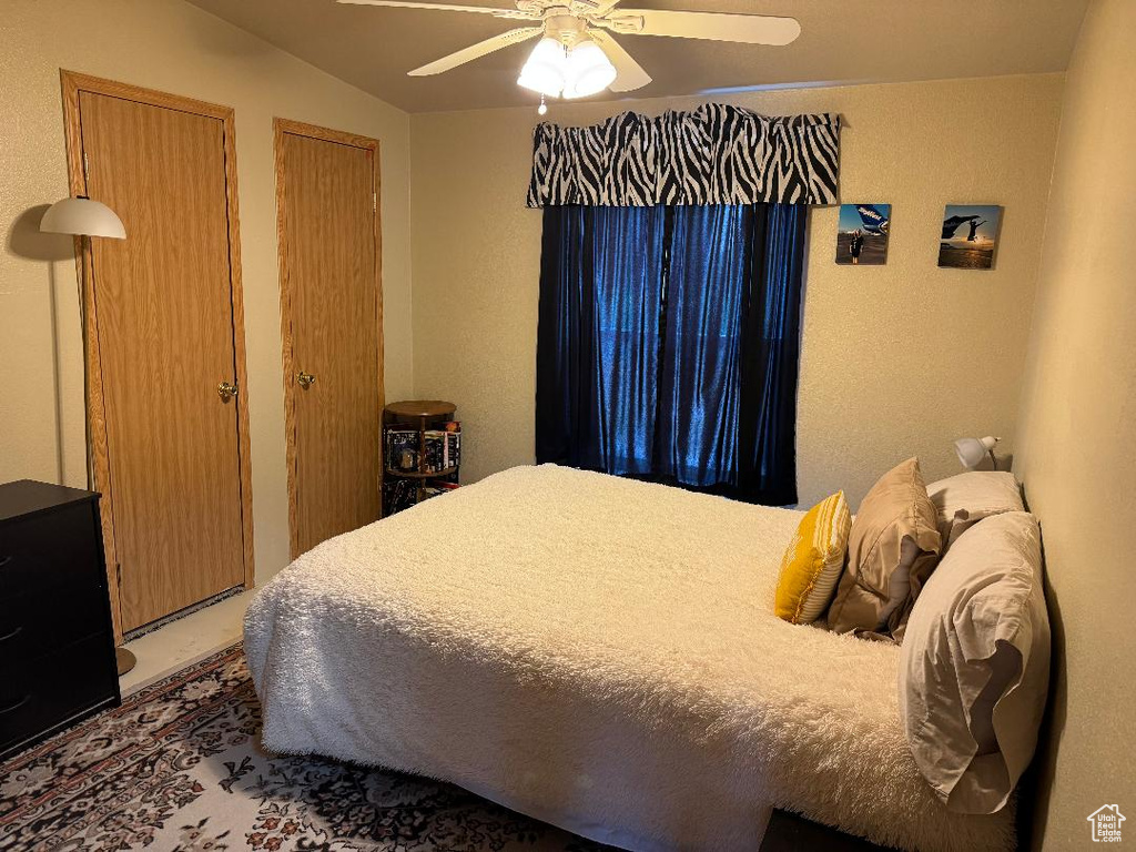 Bedroom with two closets and a ceiling fan