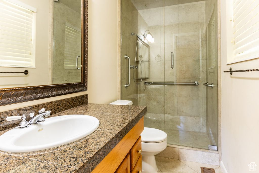 Full bathroom with a stall shower, vanity, and tile patterned flooring