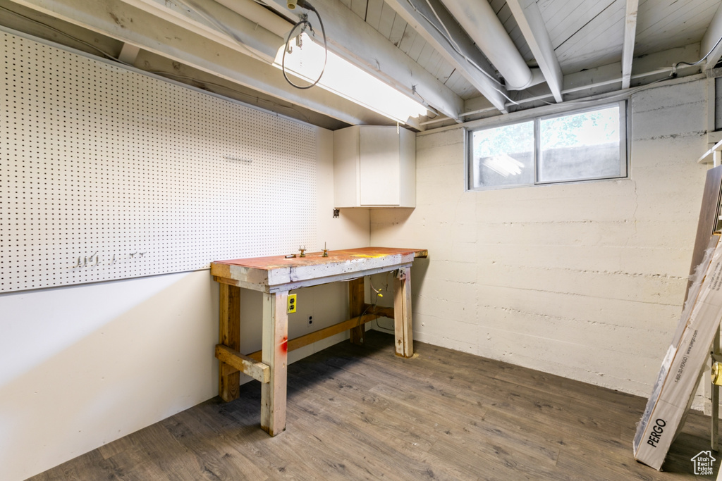 Below grade area with a workshop area and wood finished floors
