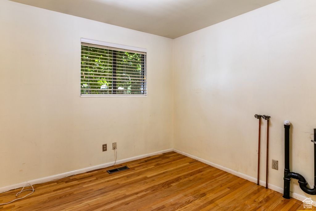 Unfurnished room with wood finished floors and baseboards
