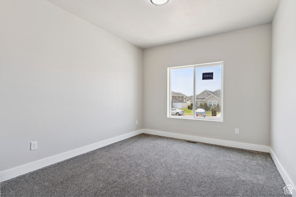 Unfurnished room featuring carpet and baseboards