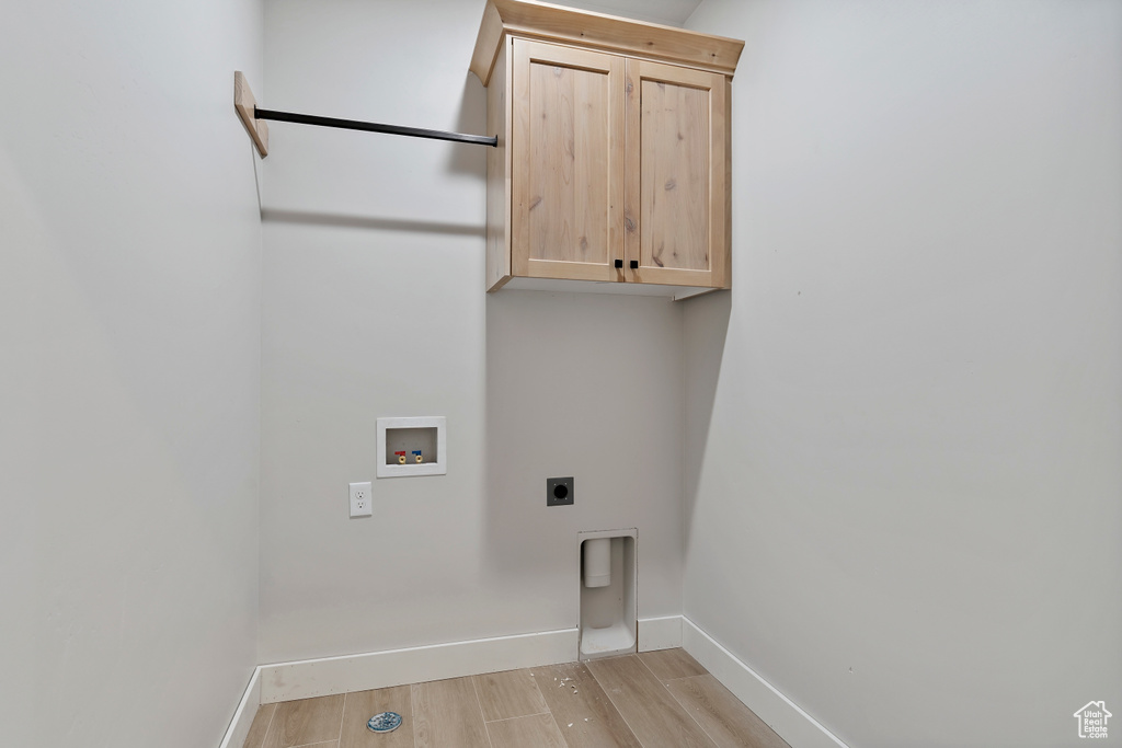 Washroom featuring cabinet space, electric dryer hookup, light wood finished floors, and hookup for a washing machine