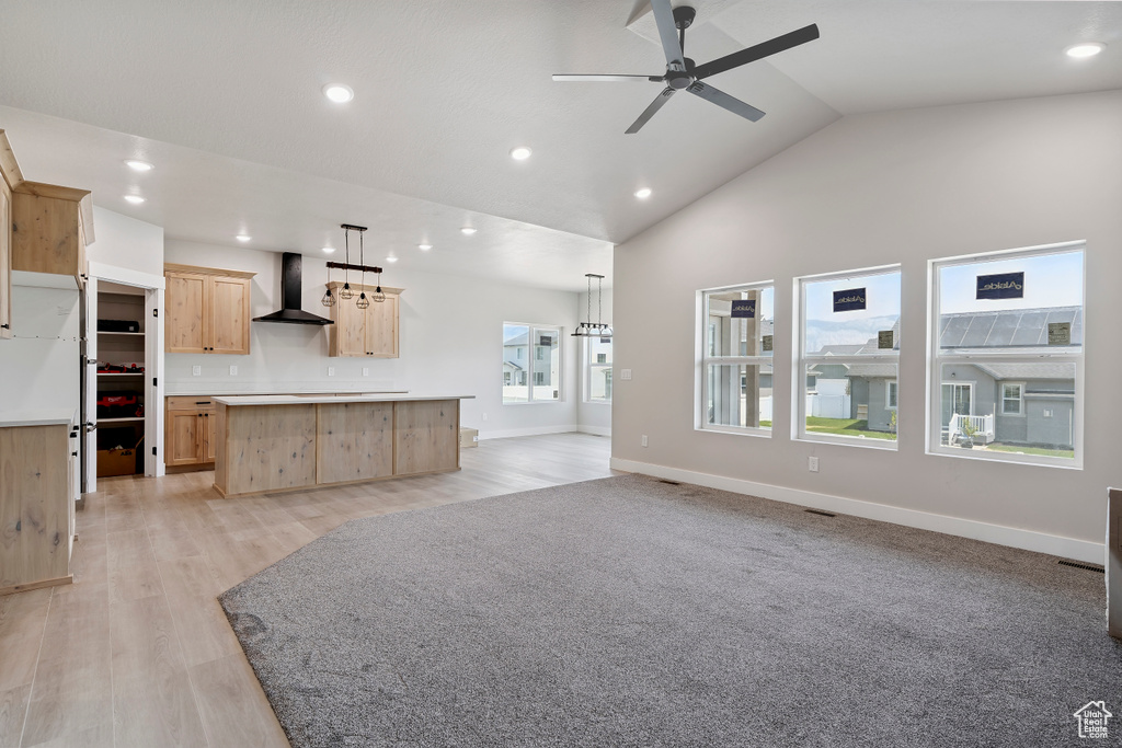 Unfurnished living room with a ceiling fan, recessed lighting, vaulted ceiling, and light wood-style floors