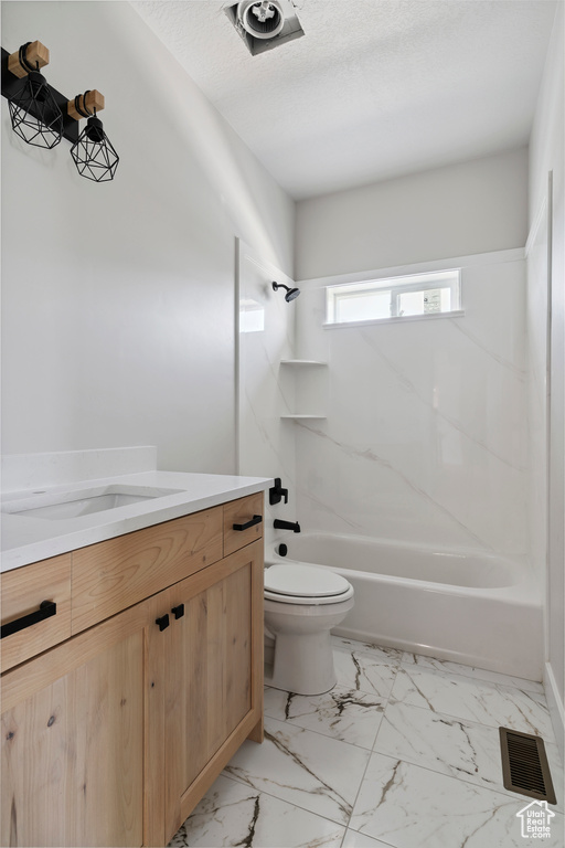 Bathroom featuring vanity,  shower combination, marble finish floors, and a textured ceiling