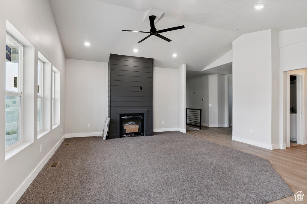 Unfurnished living room with lofted ceiling, a fireplace, ceiling fan, recessed lighting, and wood finished floors