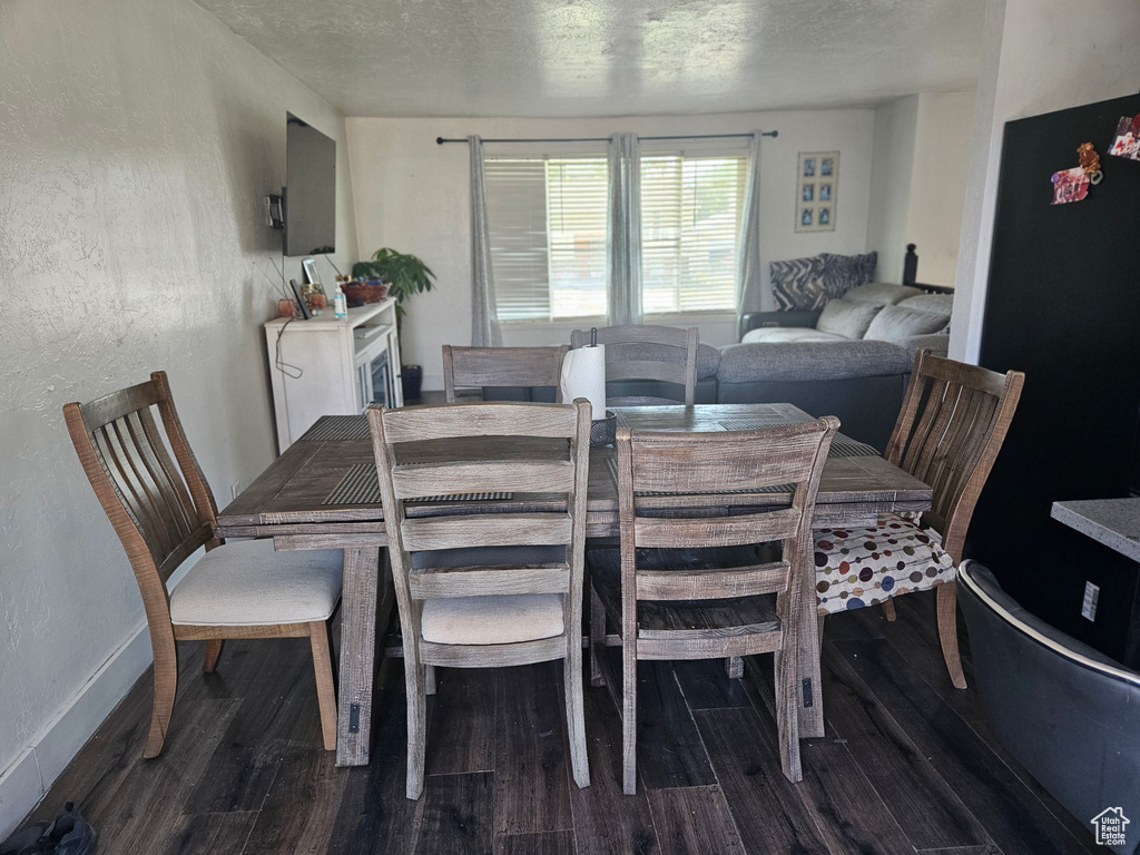 Dining area featuring wood finished floors and a textured ceiling