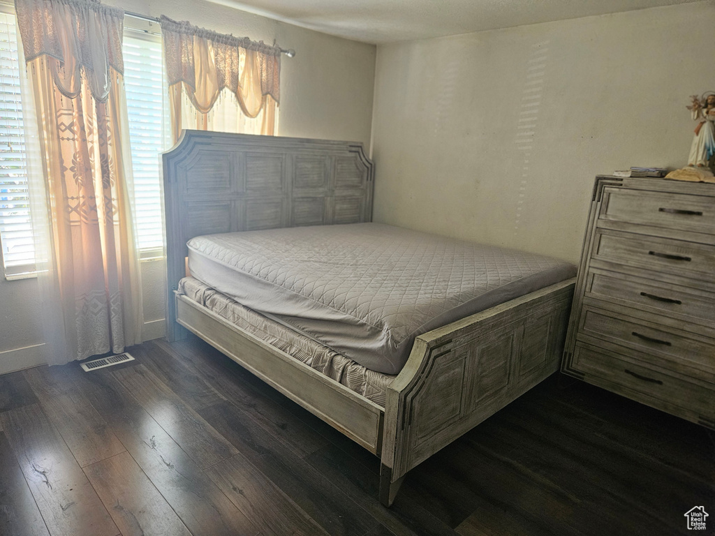 Bedroom featuring wood finished floors and multiple windows