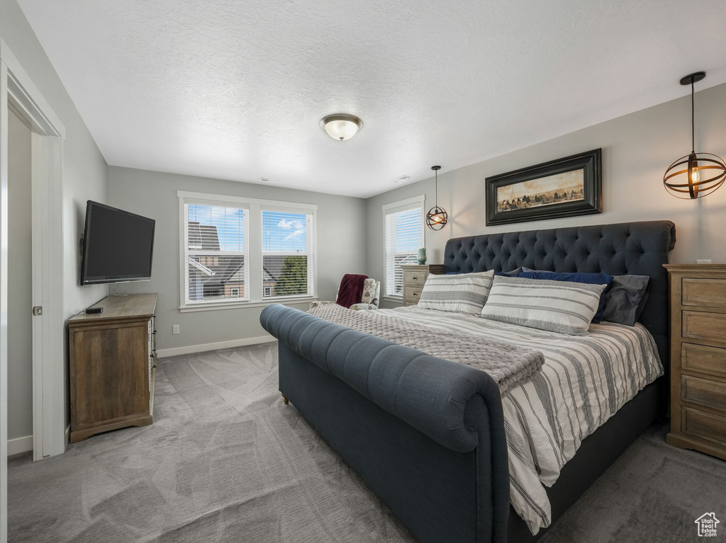 Bedroom with light colored carpet and baseboards