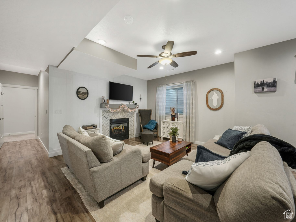 Living area with wood finished floors, a ceiling fan, a tile fireplace, and recessed lighting
