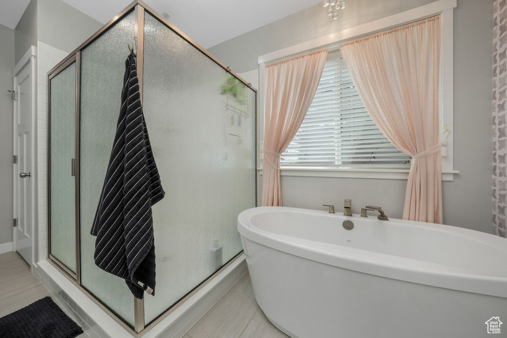 Full bath with a stall shower and a soaking tub