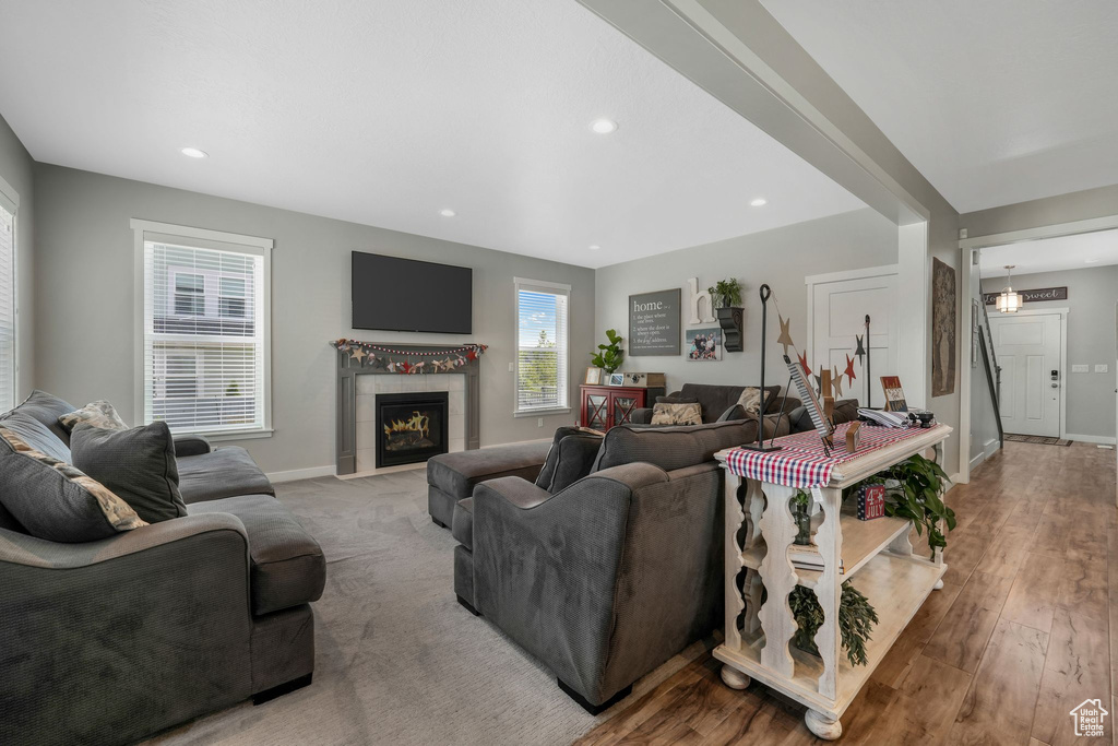 Living area with a tile fireplace, recessed lighting, and wood finished floors