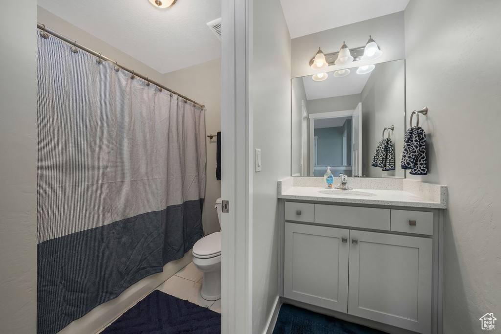 Bathroom featuring vanity, tile patterned floors, and curtained shower