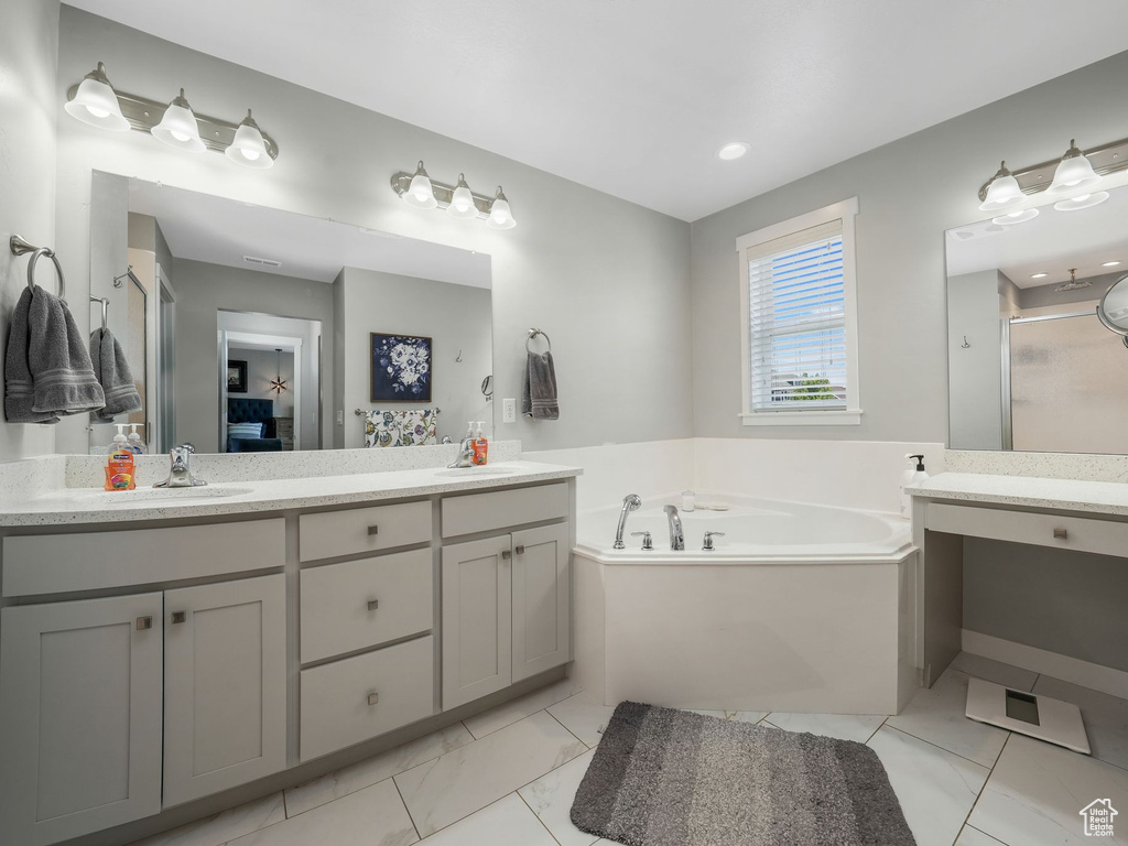 Bathroom with double vanity, a garden tub, a shower stall, and connected bathroom