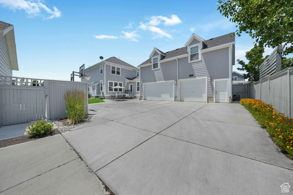 View of front of house with a garage, driveway, a residential view, and a gate