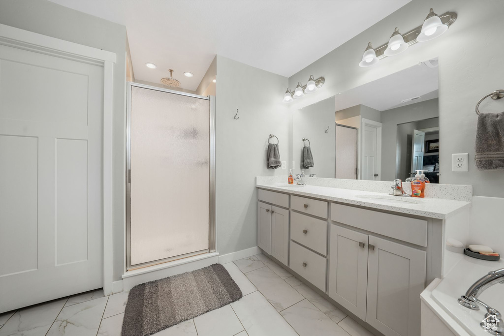 Full bath featuring marble look tile flooring, a stall shower, and recessed lighting