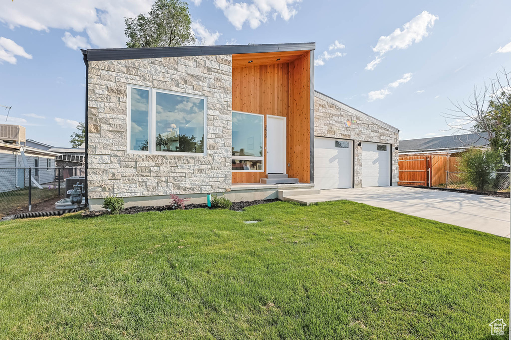 View of front of property with stone siding and concrete driveway