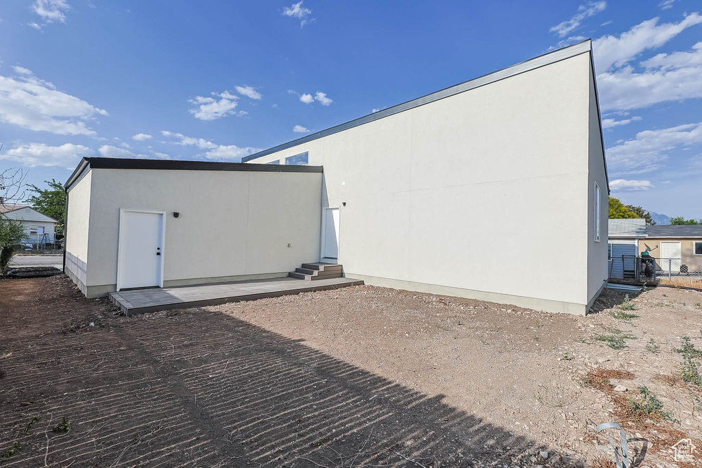 View of property exterior with entry steps, stucco siding, and a patio area