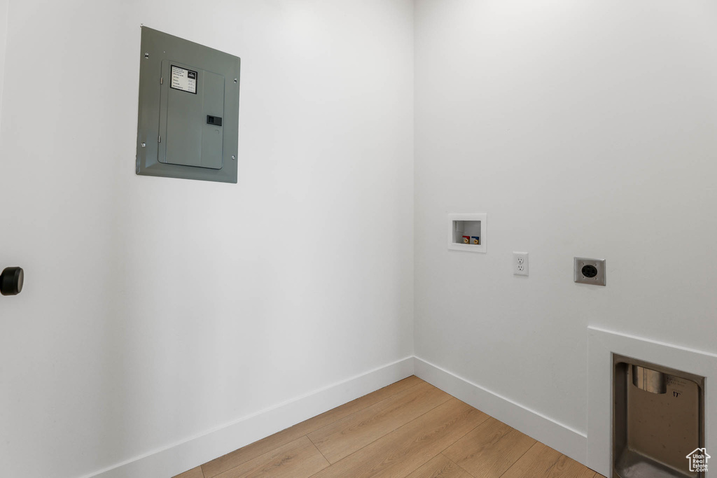 Laundry room featuring electric panel, hookup for an electric dryer, hookup for a washing machine, and light wood-style floors