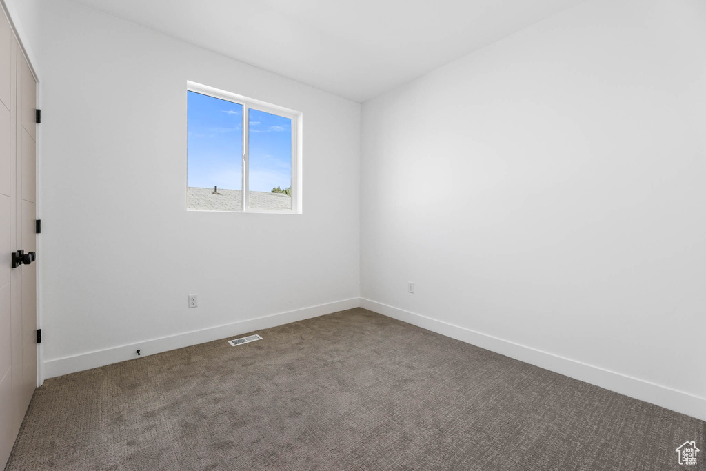 Empty room featuring carpet and baseboards