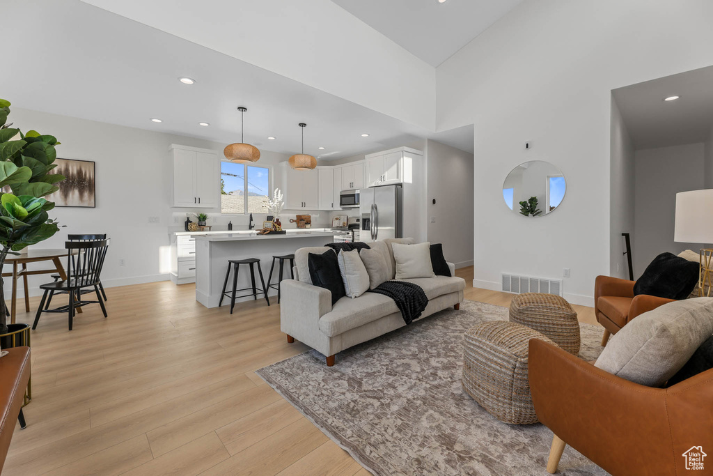 Living room with light wood-type flooring and recessed lighting