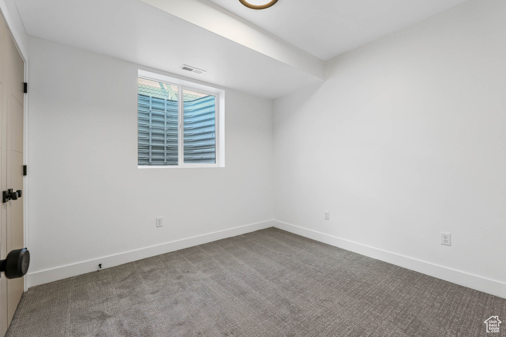 Spare room featuring baseboards and carpet