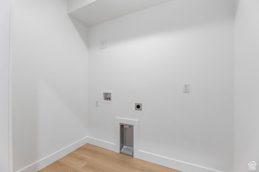 Washroom with electric dryer hookup, light wood finished floors, and hookup for a washing machine