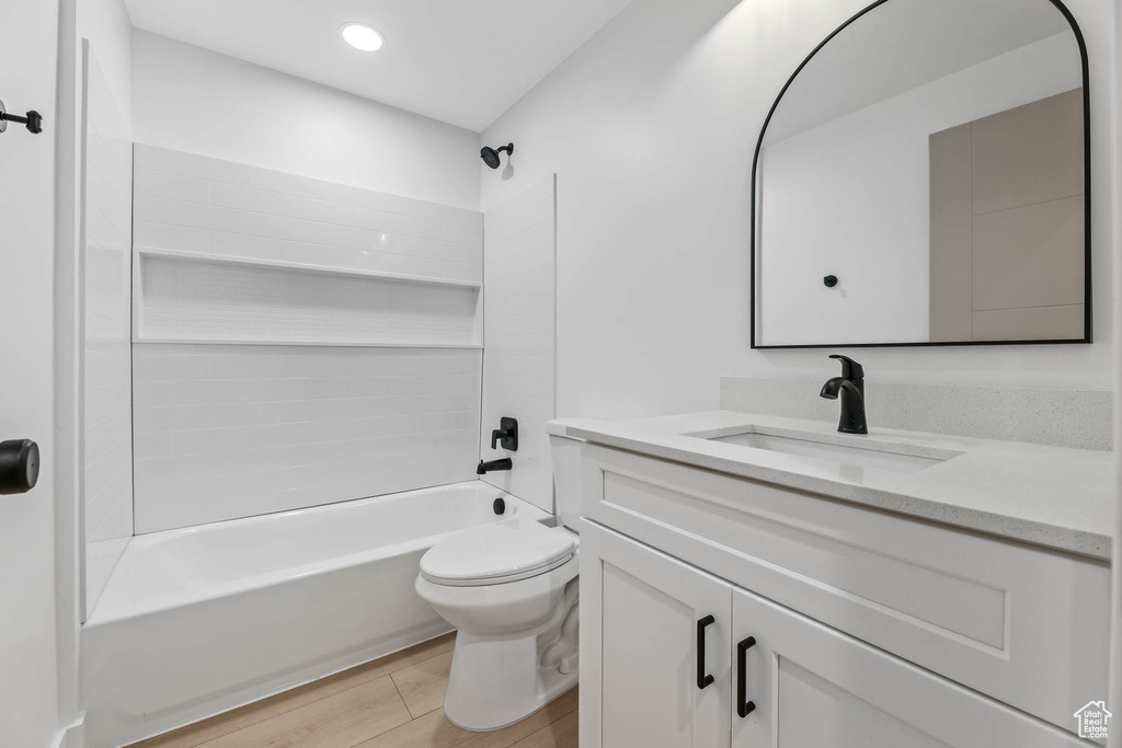 Bathroom featuring vanity, bathing tub / shower combination, wood finished floors, and recessed lighting