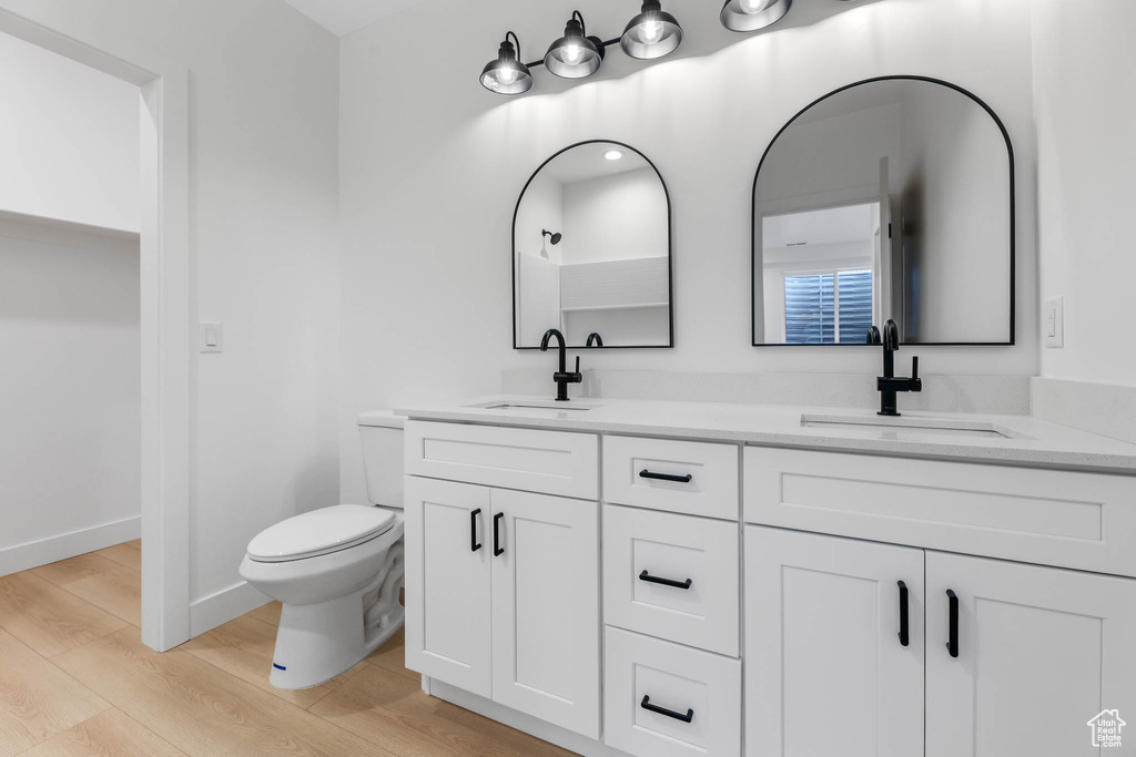 Bathroom featuring double vanity and wood finished floors