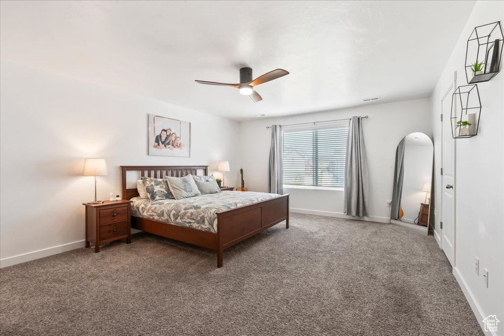Carpeted bedroom featuring a ceiling fan and baseboards