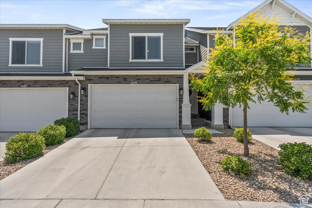 Multi unit property featuring driveway and a garage