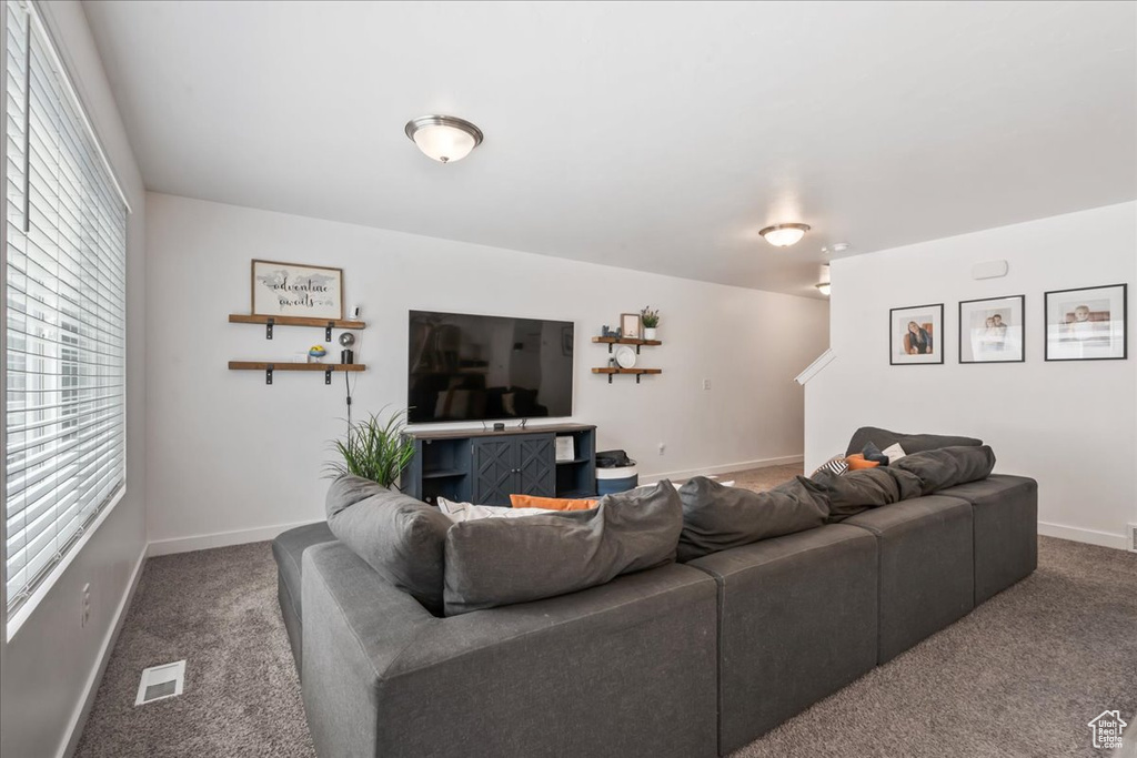 Carpeted living area featuring baseboards