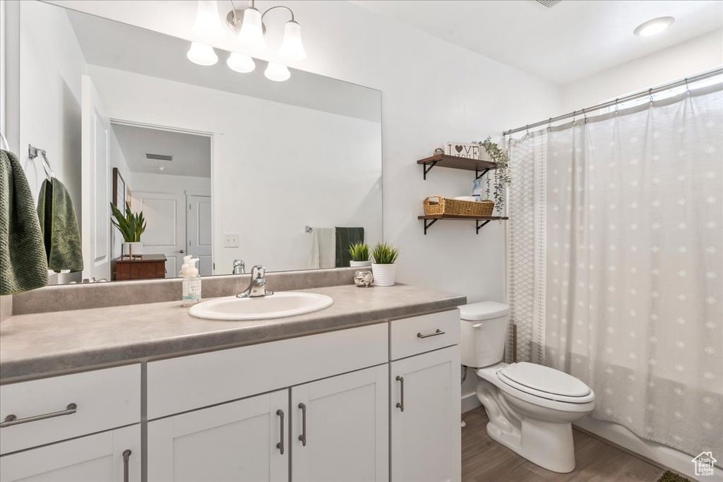 Bathroom with wood finished floors, vanity, and a shower with shower curtain