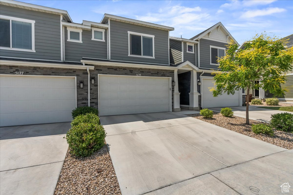 View of property featuring a garage and concrete driveway