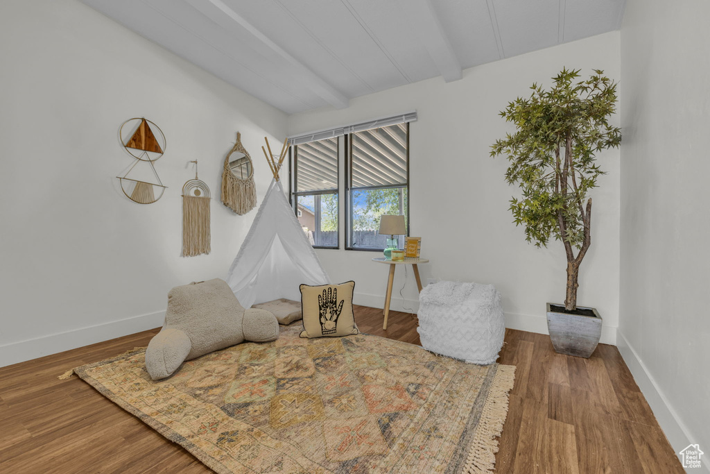 Sitting room with beam ceiling and wood finished floors